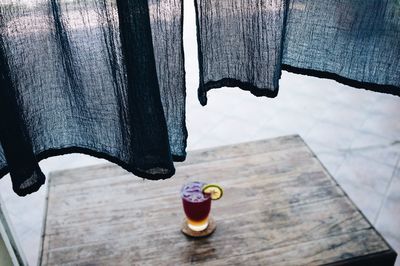 Close-up of black curtain over drink on table