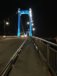 Light trails on suspension bridge against sky at night