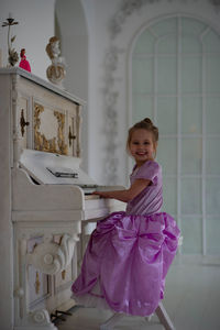 Beautiful girl playing piano in beautiful dress