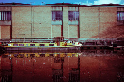 Boats moored at harbor in city