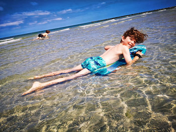 Children surfing the bodyboard on the baltic sea beach