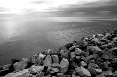 Rocks on sea shore against sky