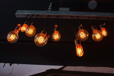 Low angle view of illuminated lanterns hanging against sky