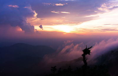 Silhouette sculpture against sky during sunset