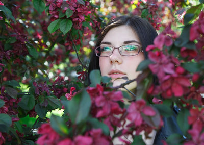 Close-up portrait of woman with red flowers