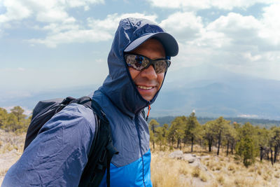 Portrait of young man standing against sky