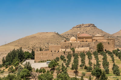 Built structure on landscape against clear sky