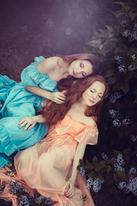 High angle view of young women sitting on grass