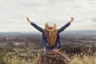 Full length of woman standing on field against sky
