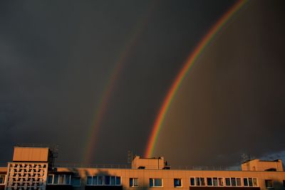 Low angle view of rainbow over buildings in city