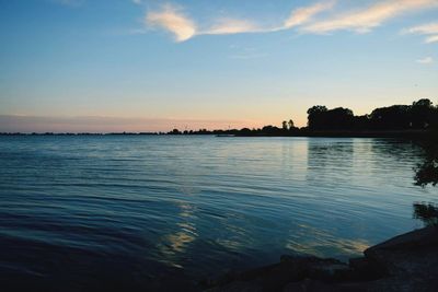 Scenic view of calm lake at sunset