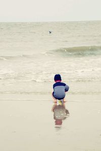 Rear view of boy standing on beach