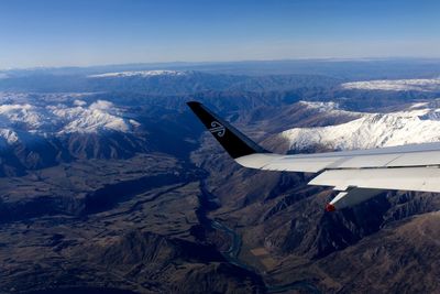 Aerial view of cityscape and mountains against sky