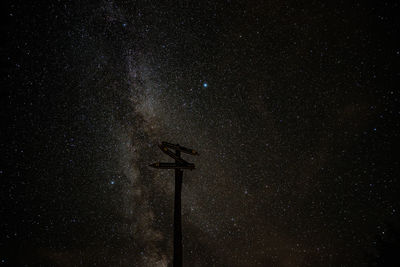 Low angle view of windmills against sky at night