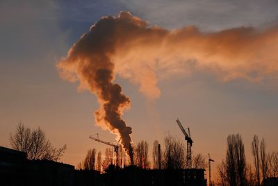 Smoke emitting from chimney against sky at sunset