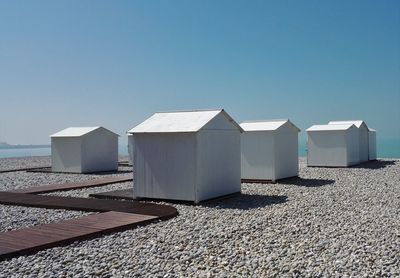 Beach huts against clear blue sky