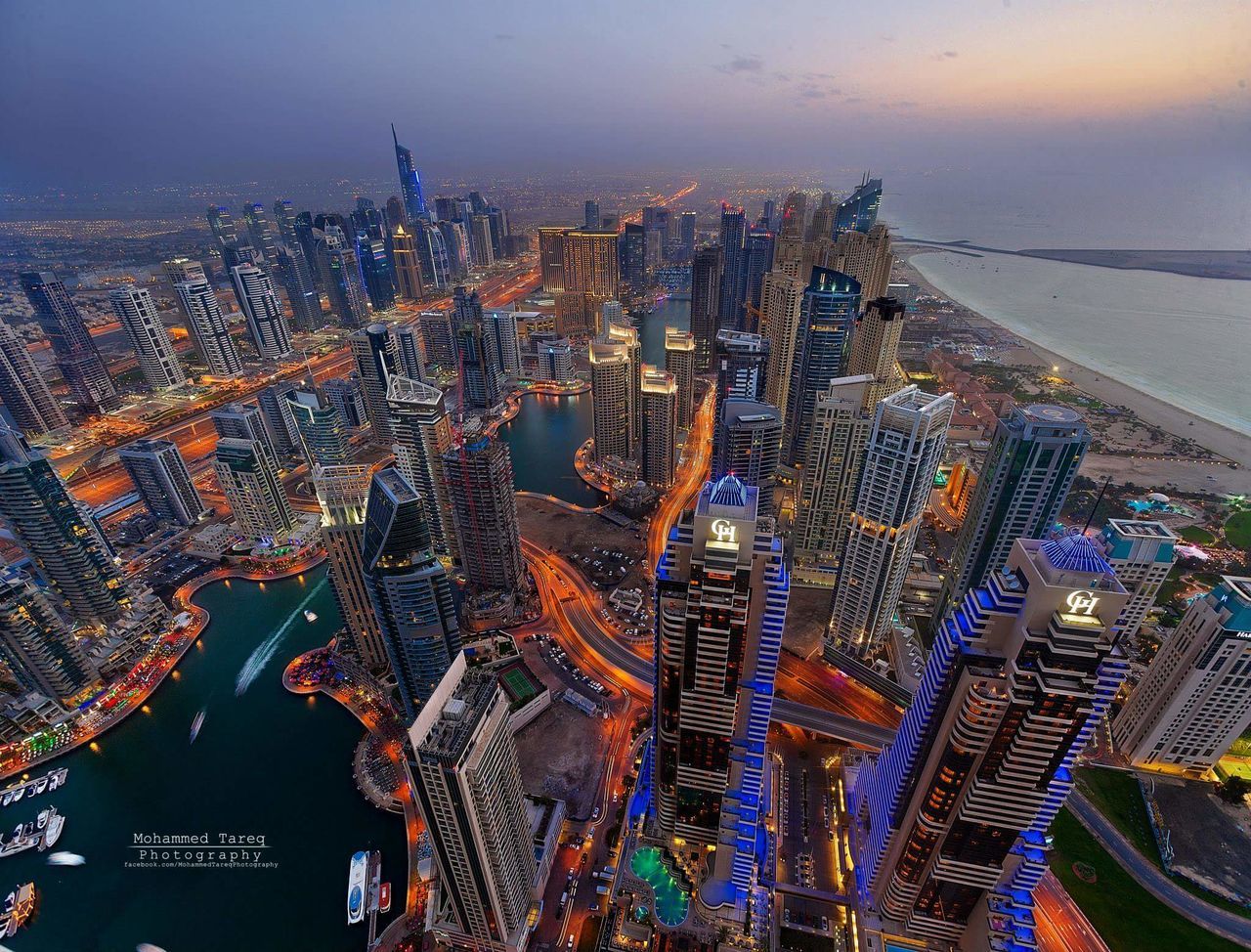 cityscape, city, architecture, building exterior, aerial view, built structure, sea, high angle view, crowded, water, skyscraper, sky, illuminated, modern, residential district, city life, office building, river, horizon over water, residential building