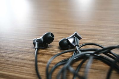 Close-up of in-ear headphones on wooden table