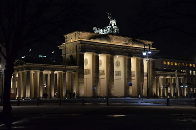 Statue in city at night