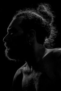 Portrait of young man against black background