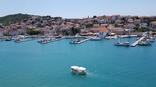 High angle view of buildings by sea against clear sky