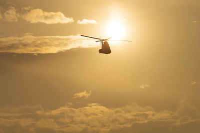 Low angle view of silhouette airplane against sky during sunset