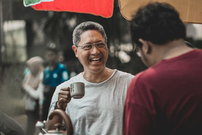 Portrait of a smiling man holding drink
