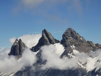 Low angle view of snowcapped mountains against sky