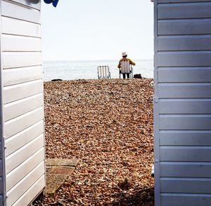 Men standing by sea against clear sky