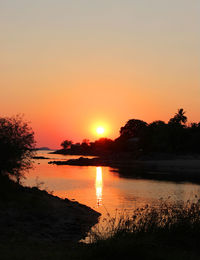 Scenic view of lake against romantic sky at sunset