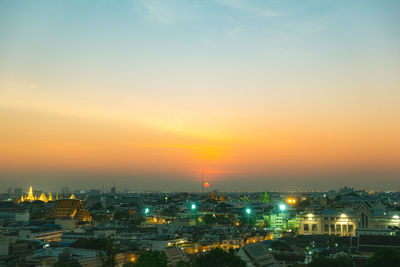High angle view of illuminated buildings against sky during sunset
