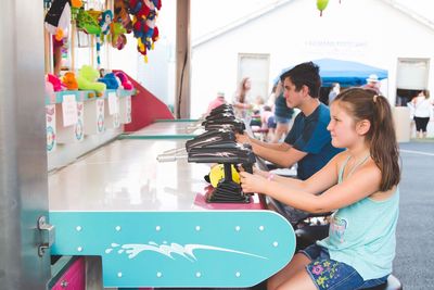 Friends playing shooting game at carnival