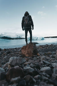 Hiking on a glacier in iceland, breathtaking views, traveler stands on stone