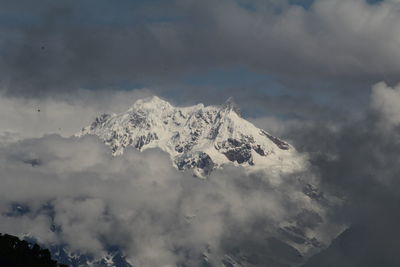 Snow covered mountains against cloudy sky