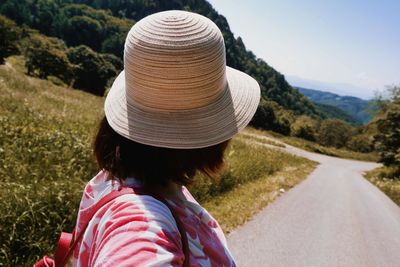 Rear view of woman wearing hat on road