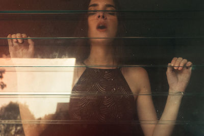 Portrait of woman seen through window