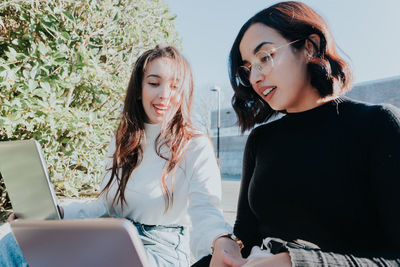 Businesswoman helping colleague on sunny day