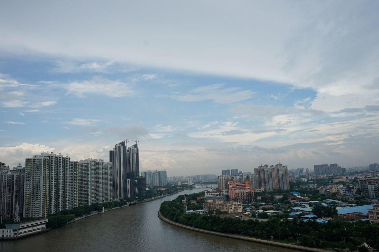 architecture, building exterior, built structure, city, cityscape, sky, river, water, cloud - sky, skyscraper, residential building, cloud, transportation, residential district, waterfront, cloudy, bridge - man made structure, office building, city life, modern