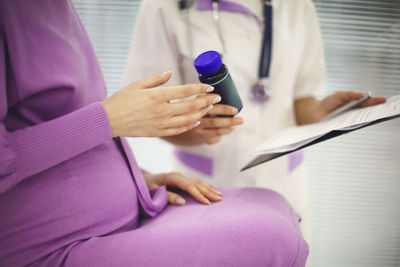 Midsection of doctor examining patient at clinic