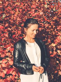 Woman standing against leaves during autumn