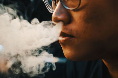 Close-up of man emitting smoke