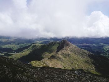 Scenic view of mountain range against cloudy sky