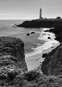 Black and white landscape of pigeon point lighthouse with ocean and rocky coast in foreground