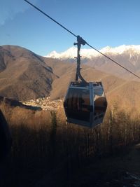 Overhead cable car and mountains against sky