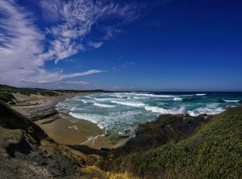 Scenic view of beach against blue sky