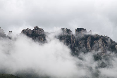 Low angle view of foggy weather against sky