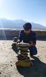 Full length of man stacking stone outdoors