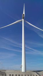 Low angle view of windmill against blue sky