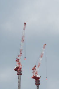 Cranes at construction site against sky