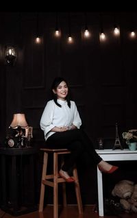 Portrait of a smiling young woman sitting on chair